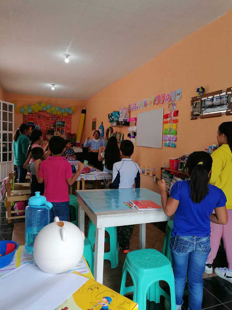 niños realizando una actividad parados, en un aula