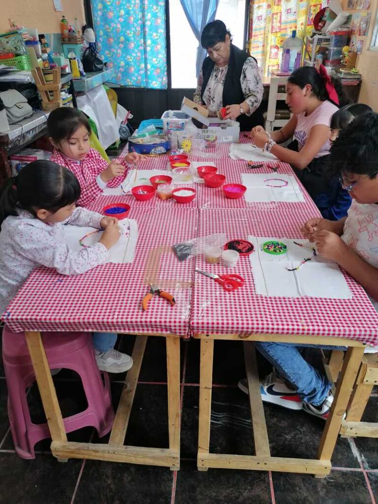 niños haciendo pulseras en una mesa