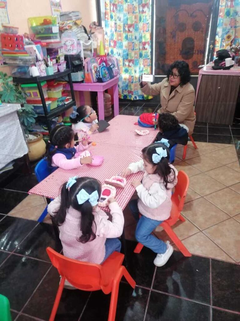 niños sentados con su maestraen un aula de clase