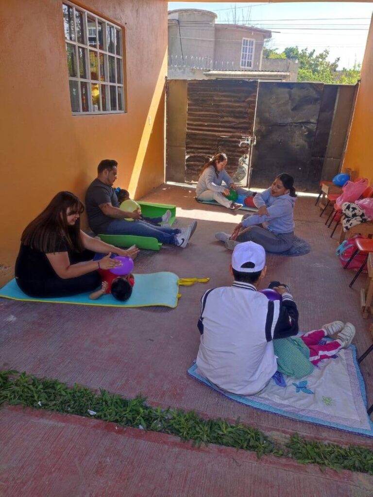padres sentados en el suelo haciendo ejercicios con sus bebes